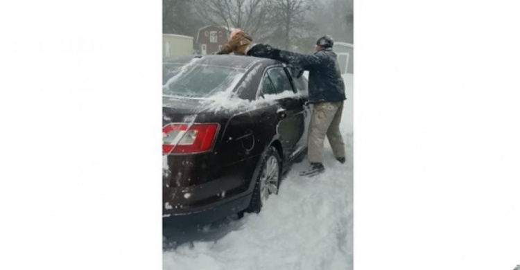 Отец очистил авто от снега своим сыном (ВИДЕО)